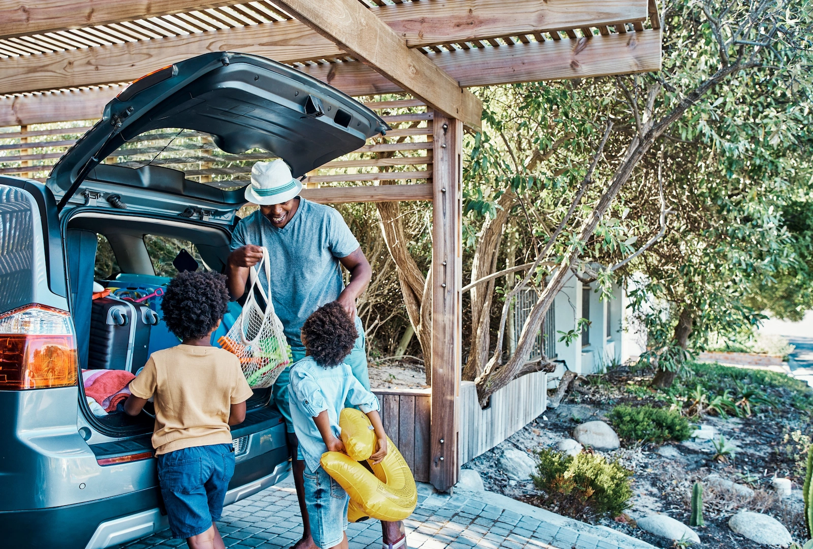 Dad and children unloading items from a car, highlighting auto insurance protection tailored to family needs.