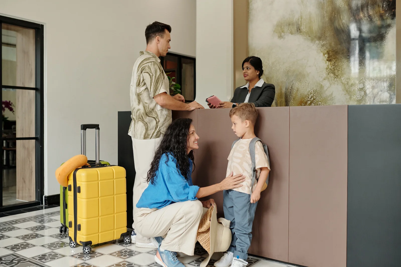 Family checking into temporary accommodations with luggage, representing loss of use coverage for additional living expenses after a covered home insurance claim.