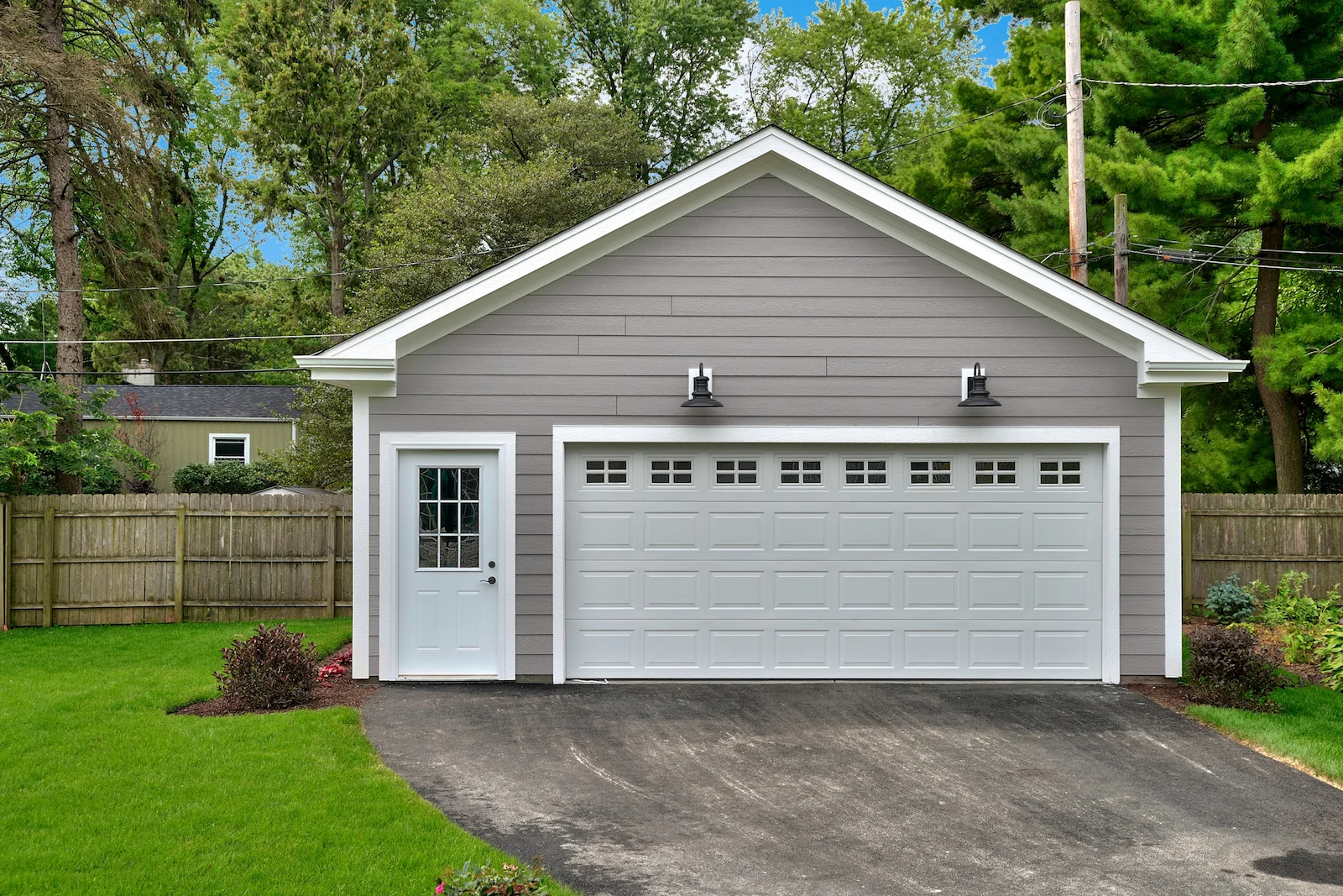Detached garage and backyard fence beside a residential property, representing other structures coverage under homeowners insurance.