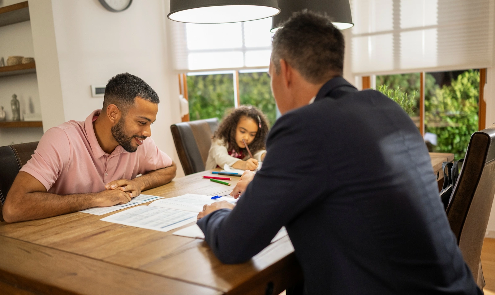 Homebuyer discussing paperwork with a real estate advisor, illustrating personalized homeowners insurance support.