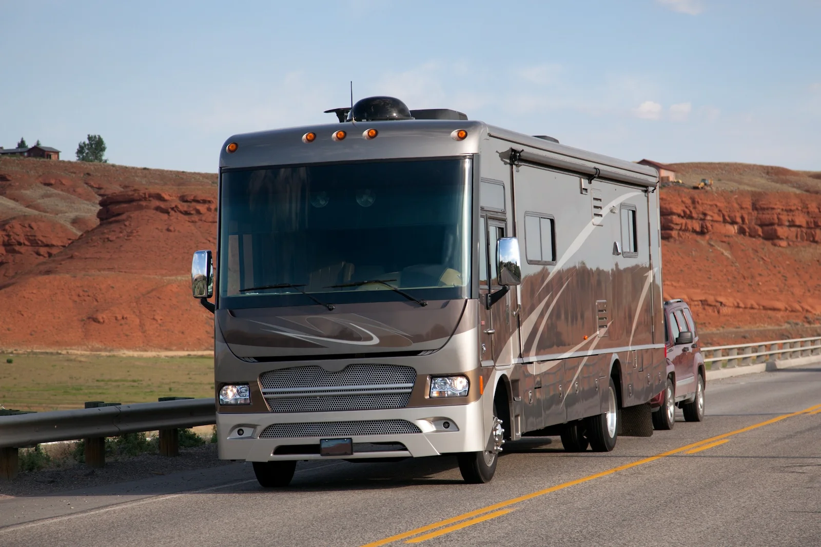 Motorhome traveling on an open highway through a scenic landscape, representing recreational vehicle insurance coverage for motorhome owners.