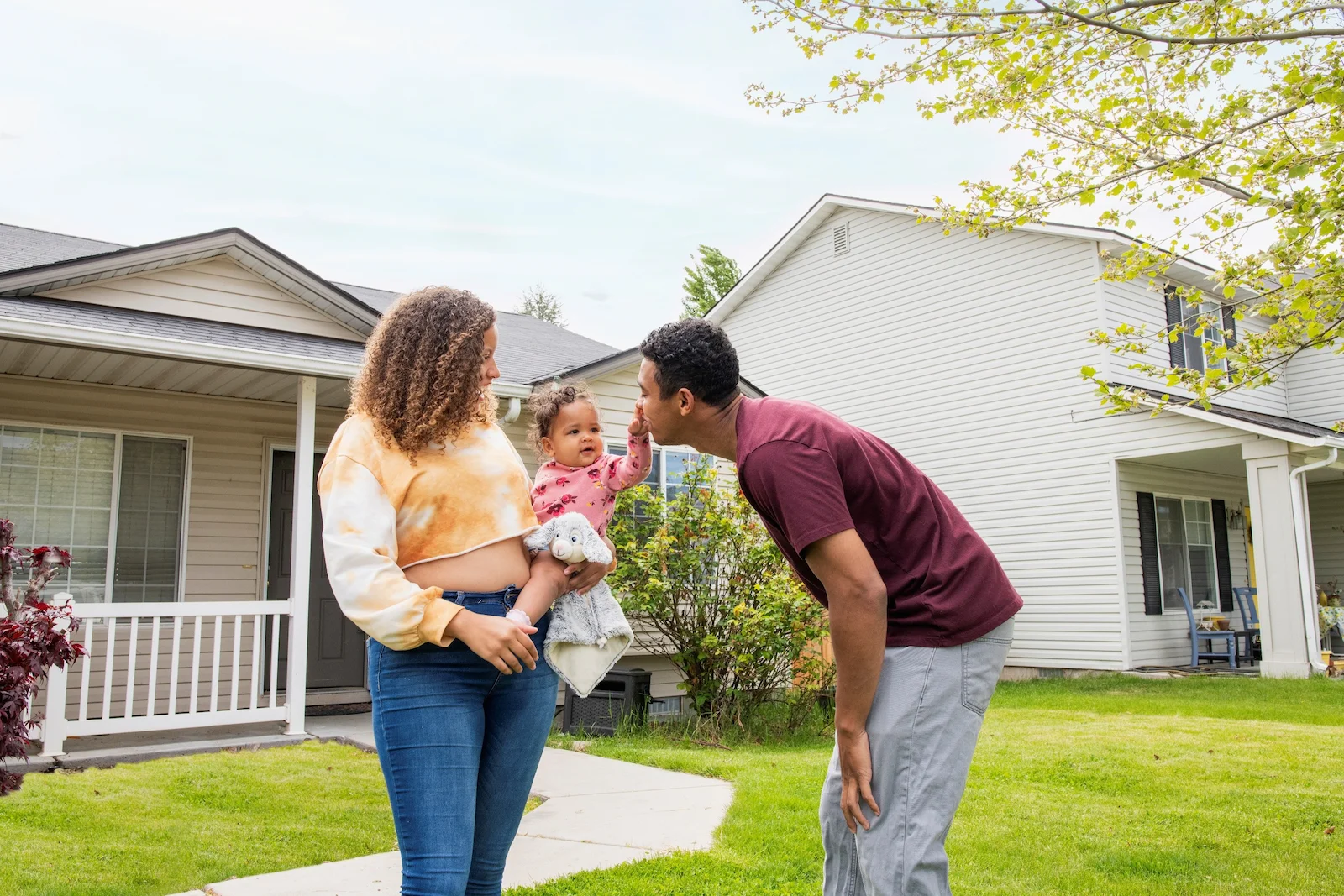 Family standing outside a home, representing umbrella insurance protection that extends liability coverage for homeowners.