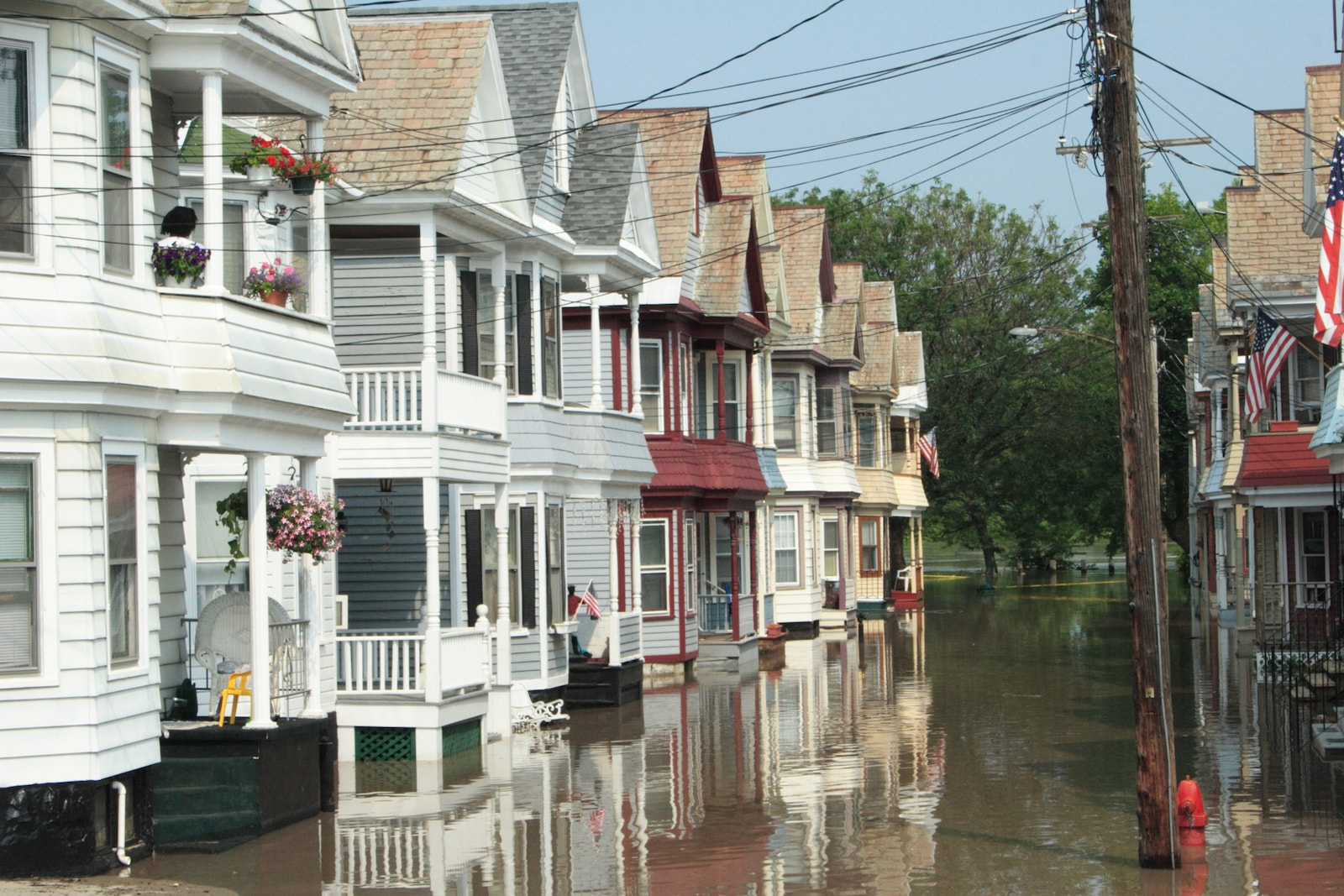 Flooded residential street with rows of homes surrounded by water, highlighting the need for flood insurance coverage.